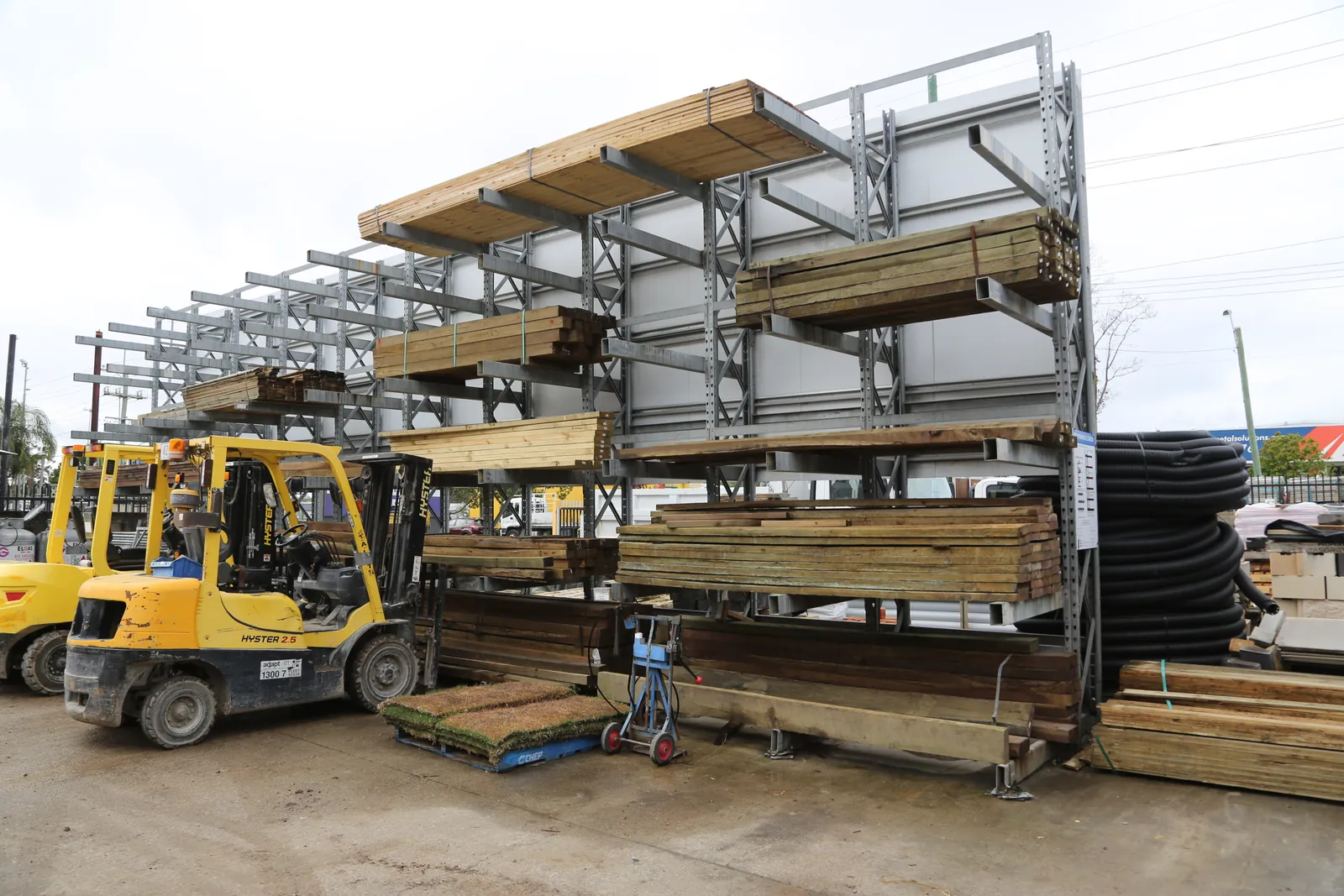 Outdoor timber yard rack stacked with hardwood and treated pine at Miller's Mitre 10 Narangba